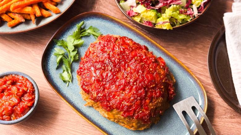 Super moist turkey meatloaf on platter with chutney and sides